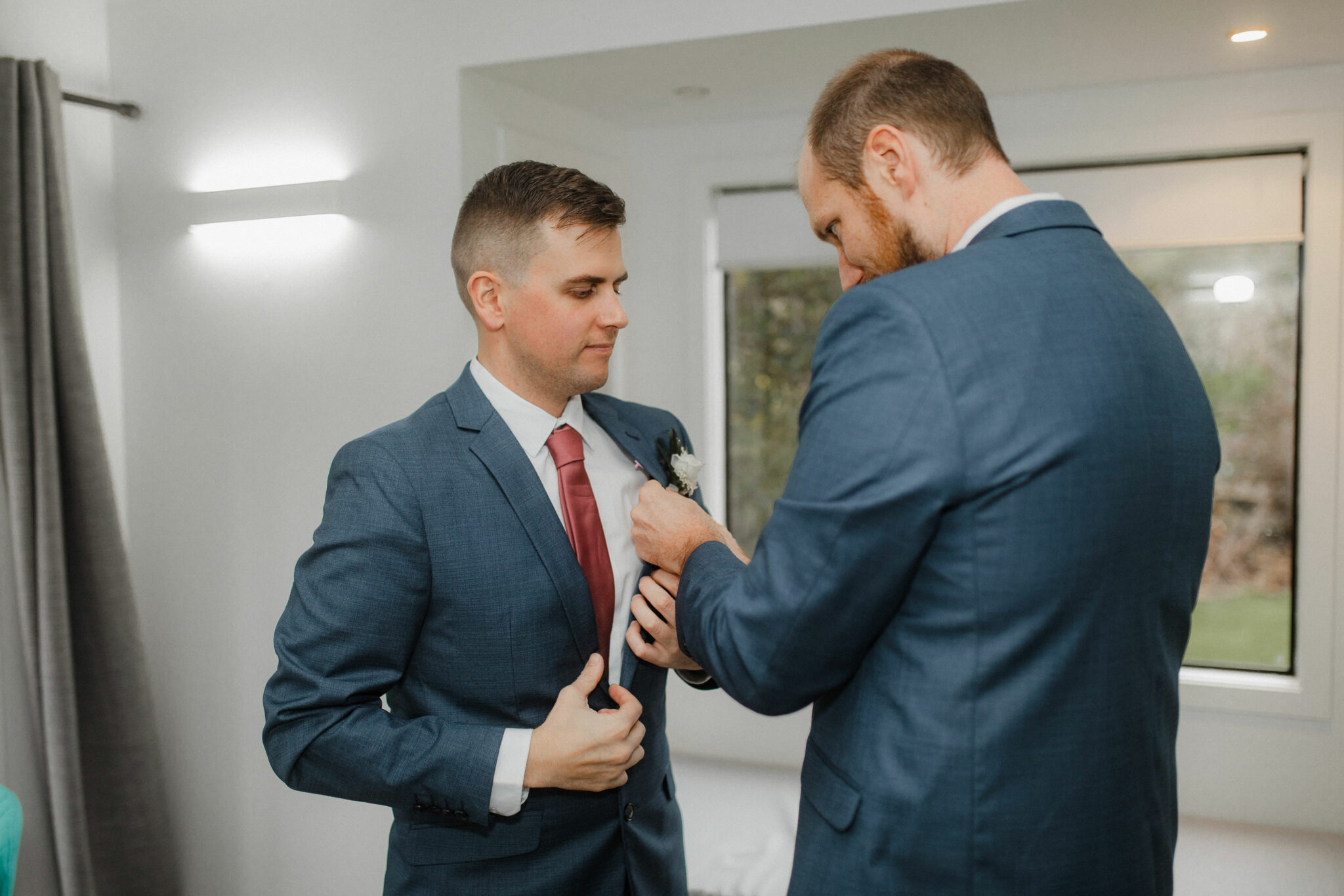 groom putting on suit jacket