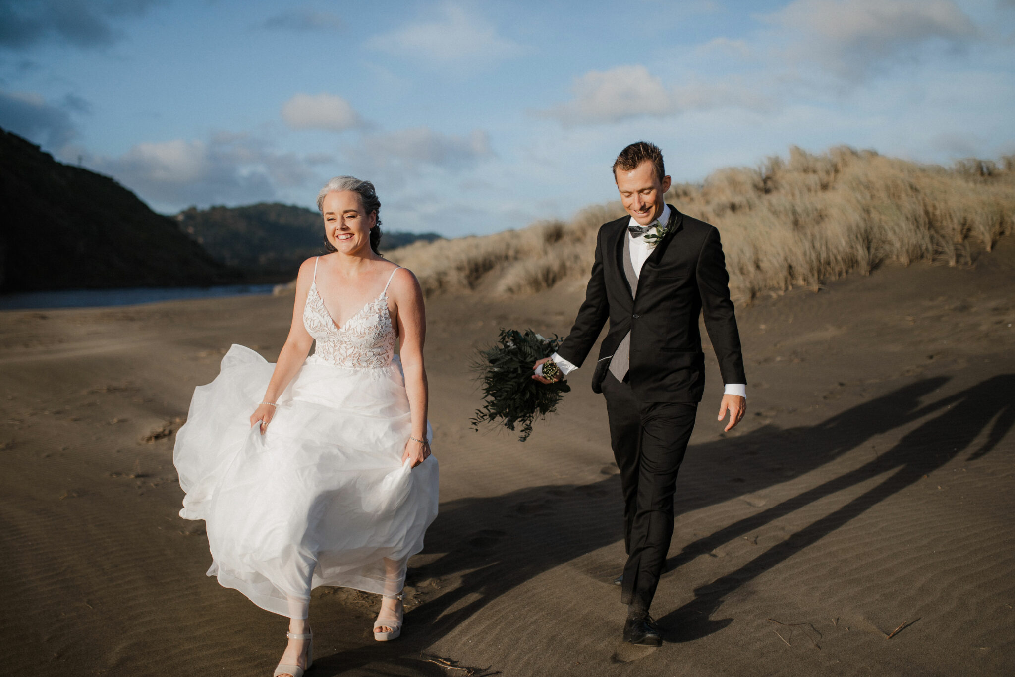 bride and groom strolling on the beach