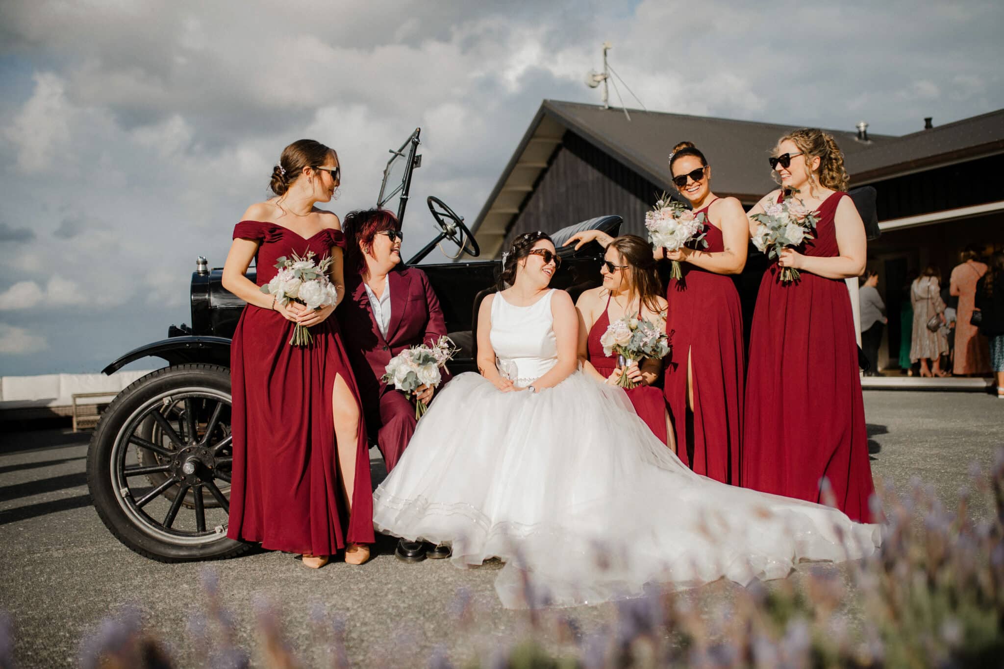 bridesmaids sitting by a car