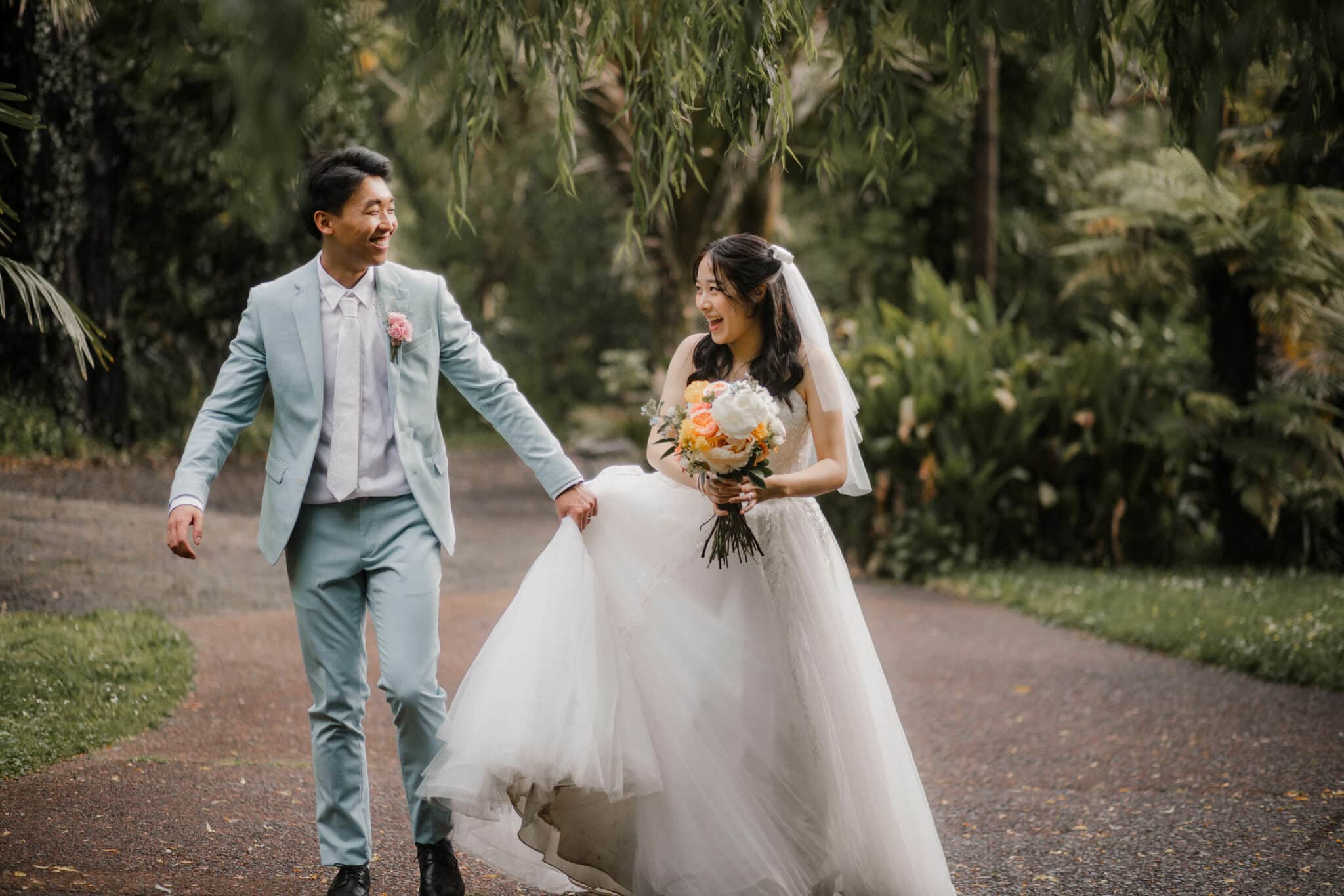 groom holding onto bride's dress