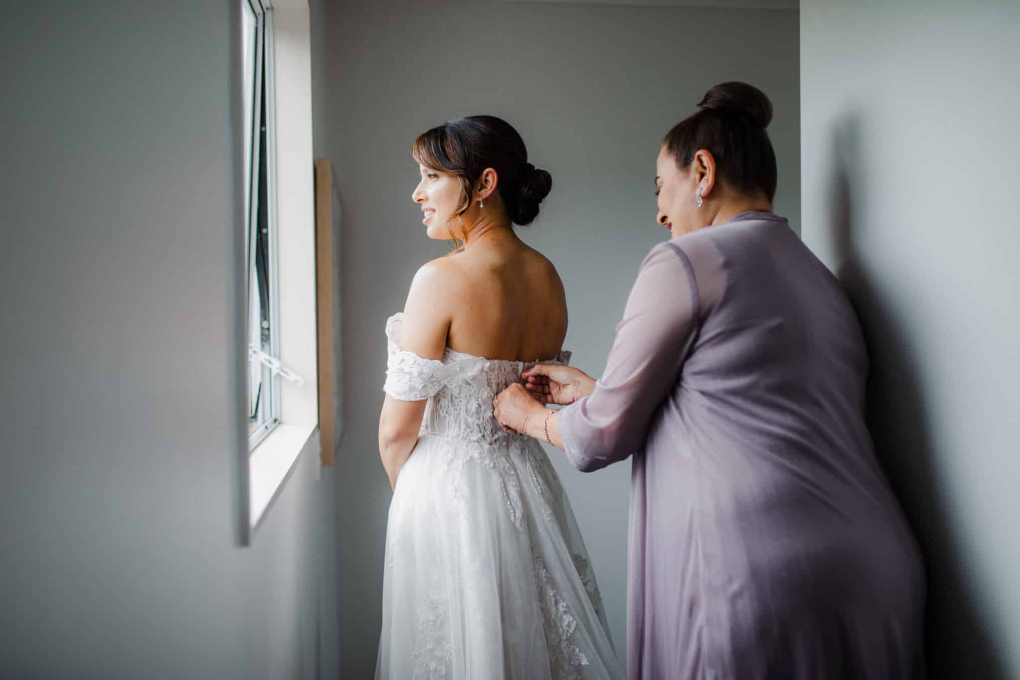 mother of the bride helping with wedding dress
